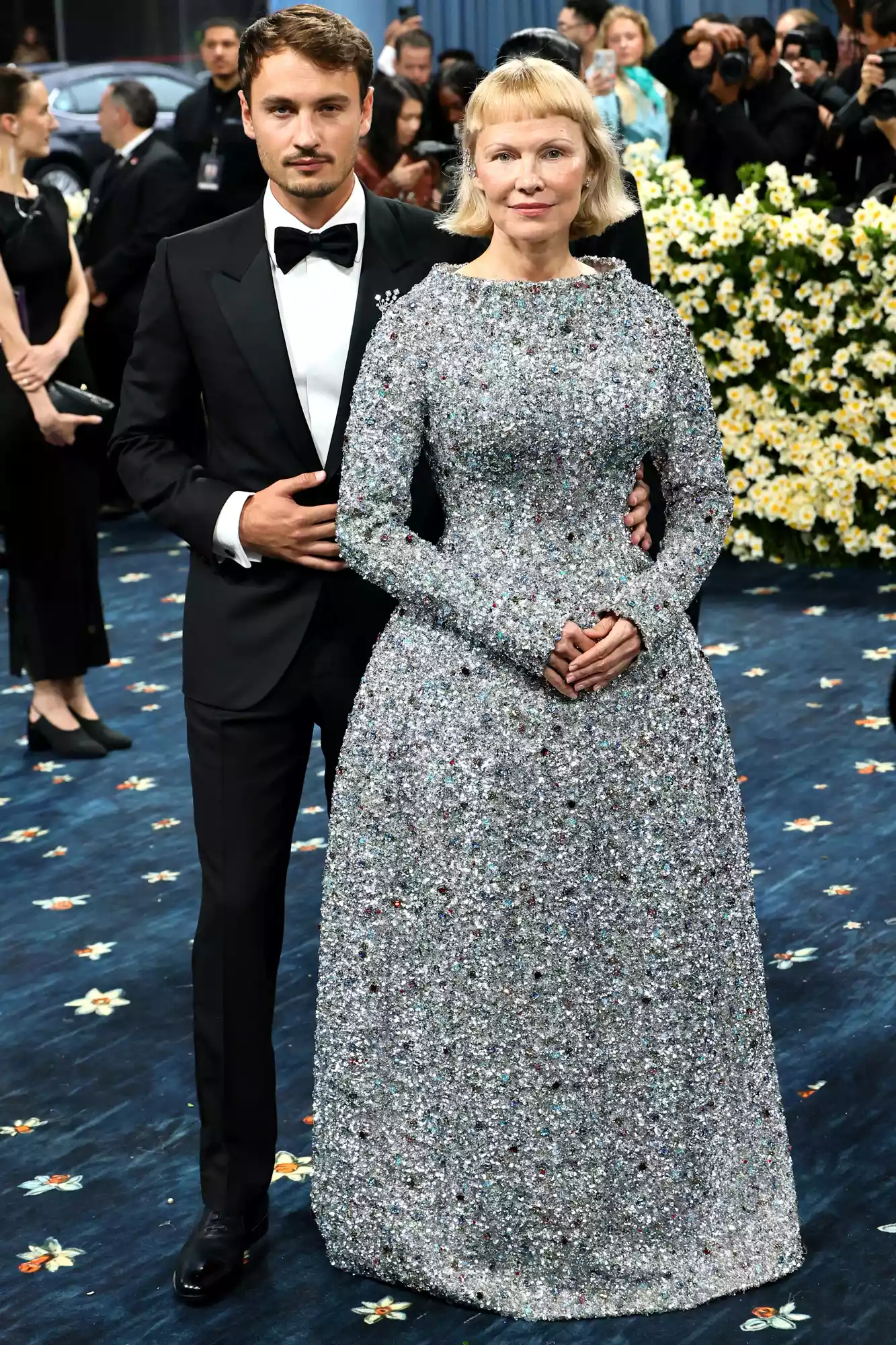 Pamela Anderson Met Gala 2025: Showcasing a chic bob, baby bangs, and a sparkling Tory Burch gown adorned with recycled diamonds, redefining red carpet elegance.
